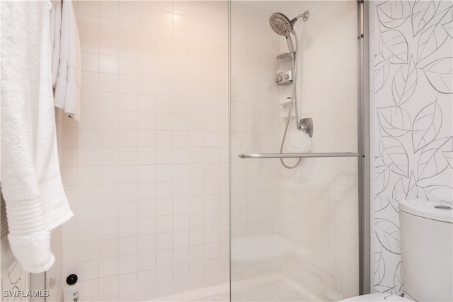 full bath featuring toilet and a stall shower
