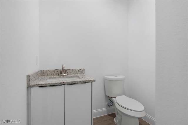 bathroom featuring hardwood / wood-style flooring, vanity, and toilet