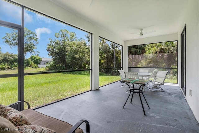 unfurnished sunroom with ceiling fan and plenty of natural light