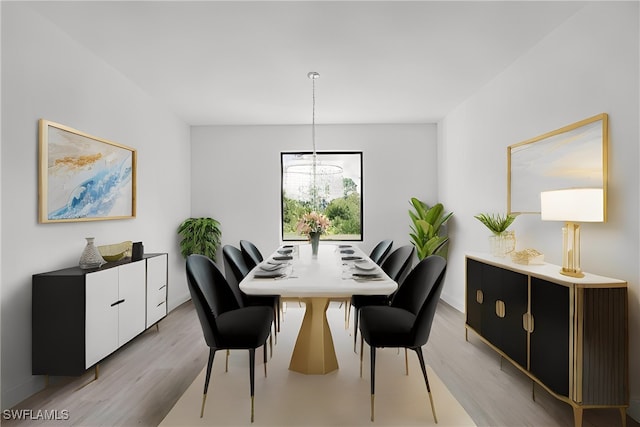 dining space featuring a notable chandelier and light hardwood / wood-style floors