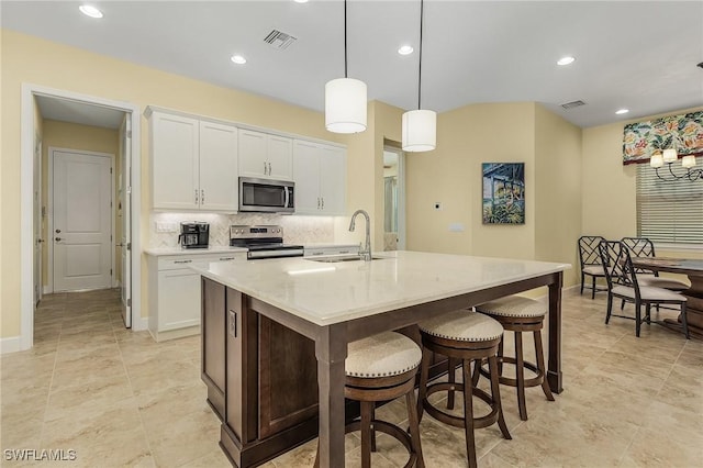 kitchen with white cabinetry, sink, a center island with sink, and appliances with stainless steel finishes