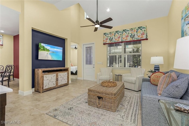 tiled living room featuring ceiling fan and a towering ceiling