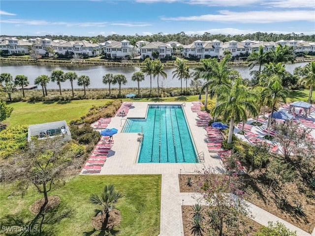 view of swimming pool with a patio area, a yard, and a water view