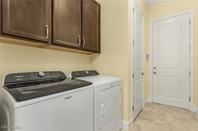 clothes washing area featuring cabinets and independent washer and dryer