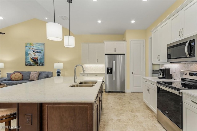 kitchen with decorative backsplash, a kitchen island with sink, and appliances with stainless steel finishes