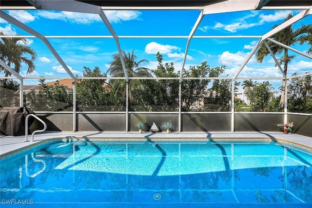 view of swimming pool featuring glass enclosure