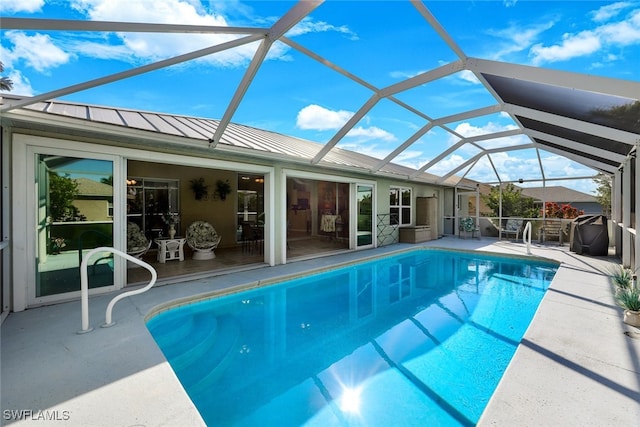 view of pool with a patio and glass enclosure