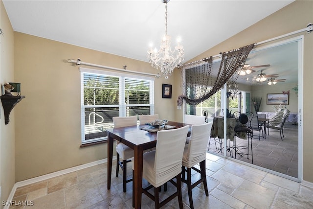 dining space featuring ceiling fan with notable chandelier and vaulted ceiling