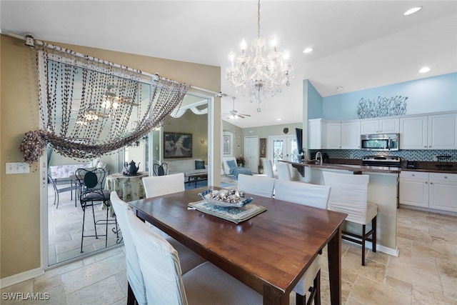 dining area with ceiling fan with notable chandelier, lofted ceiling, and sink