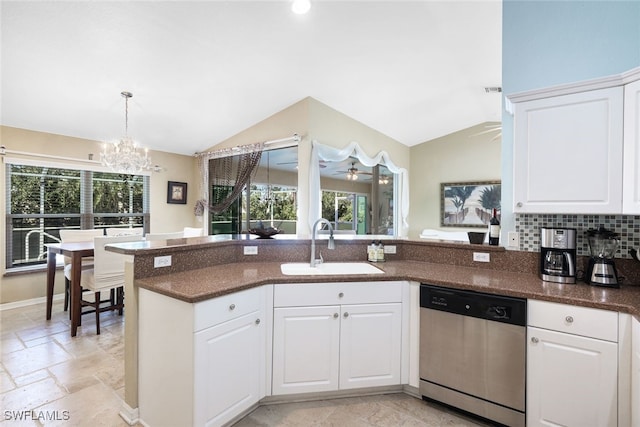 kitchen with white cabinets, a notable chandelier, dishwasher, a sink, and vaulted ceiling