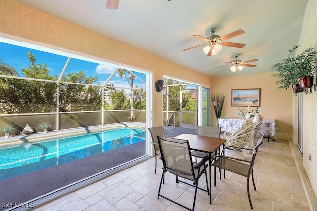 view of swimming pool featuring a patio, ceiling fan, and glass enclosure