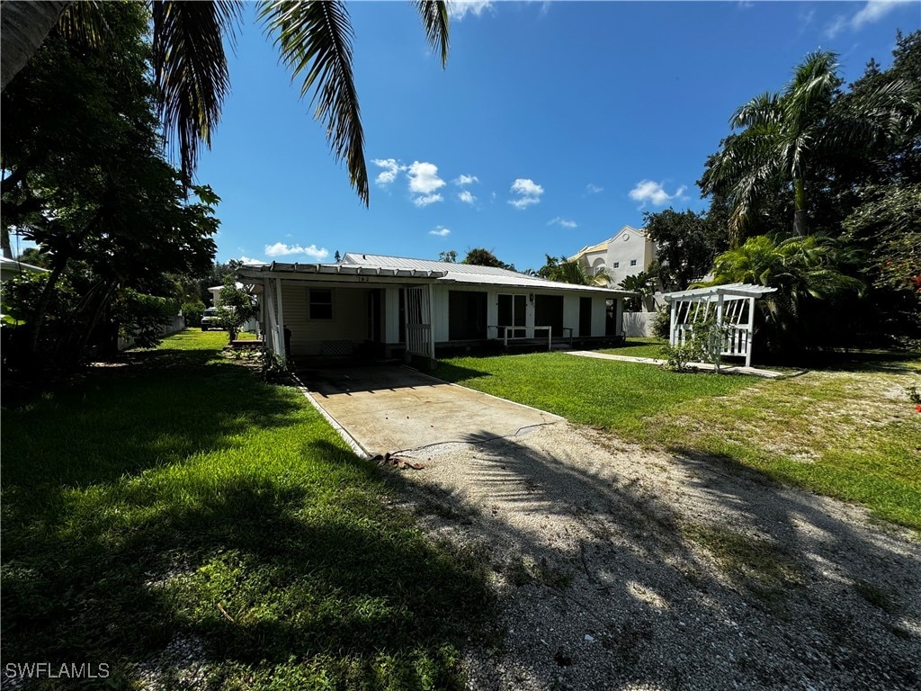 view of front of house featuring a carport and a front yard