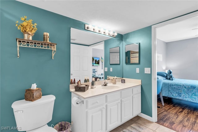 bathroom with wood-type flooring, vanity, and toilet