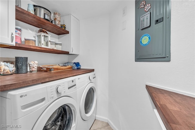 laundry area featuring light tile patterned flooring, electric panel, separate washer and dryer, and cabinets