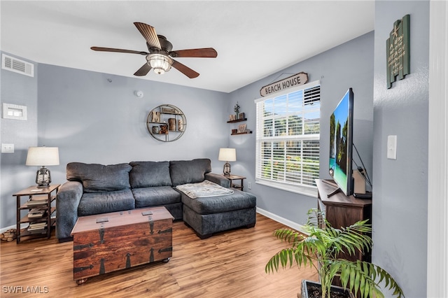 living room with light hardwood / wood-style flooring and ceiling fan