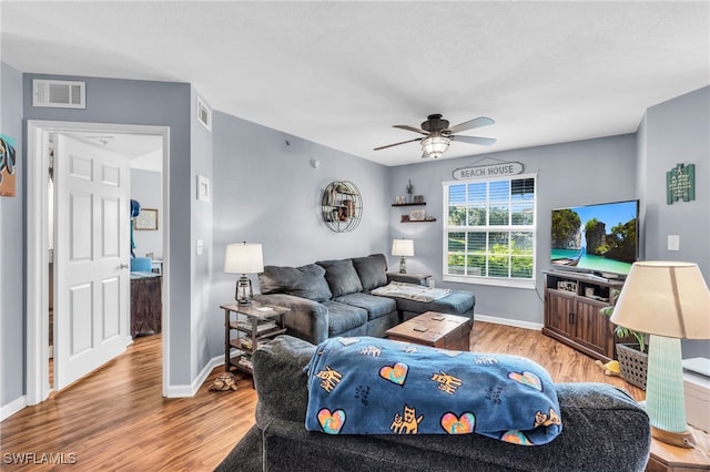 living room featuring light hardwood / wood-style floors and ceiling fan