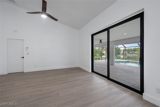 unfurnished room with ceiling fan, lofted ceiling, and light hardwood / wood-style flooring