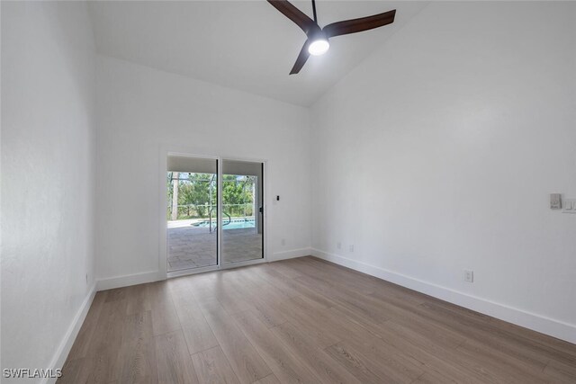 empty room with ceiling fan, light hardwood / wood-style floors, and high vaulted ceiling