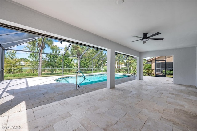 view of pool with a patio, glass enclosure, and ceiling fan