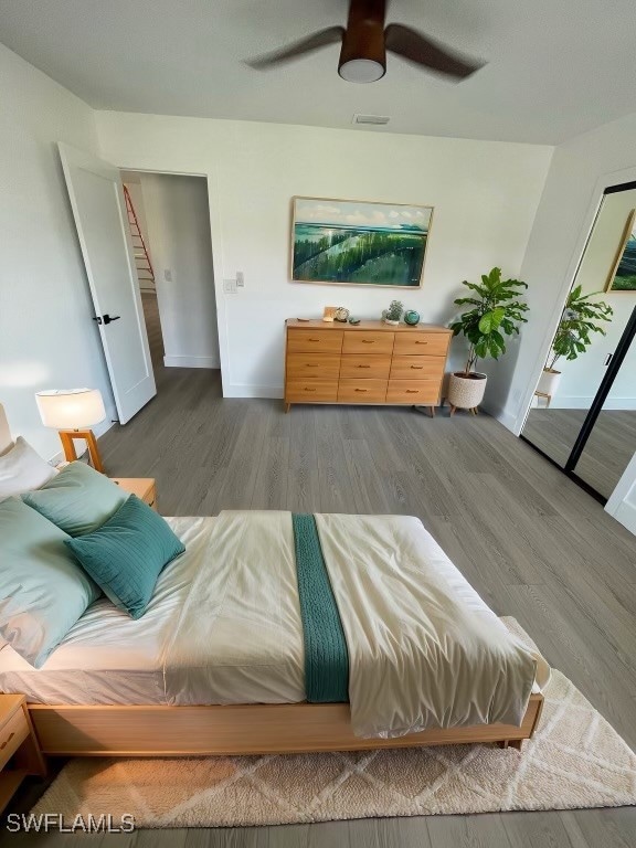 bedroom with access to exterior, hardwood / wood-style flooring, and ceiling fan