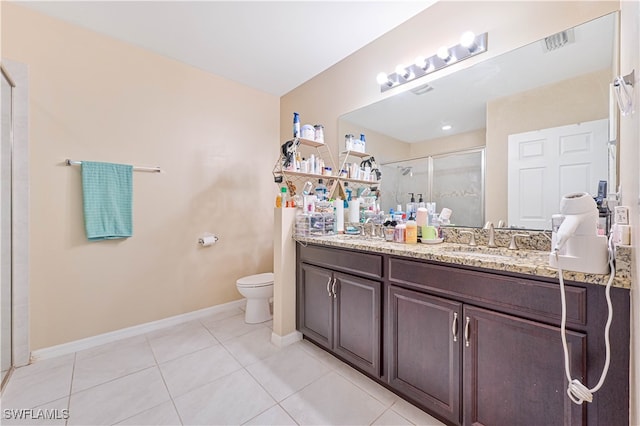 bathroom with tile patterned flooring, a shower with door, vanity, and toilet