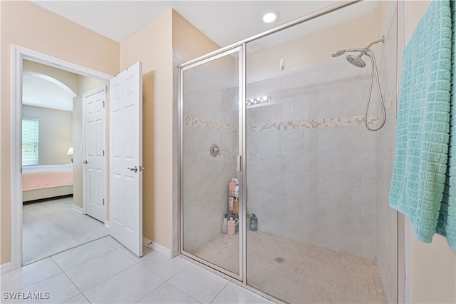 bathroom with a shower with shower door and tile patterned flooring