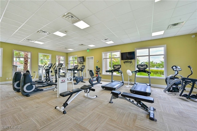 workout area with light colored carpet and a paneled ceiling