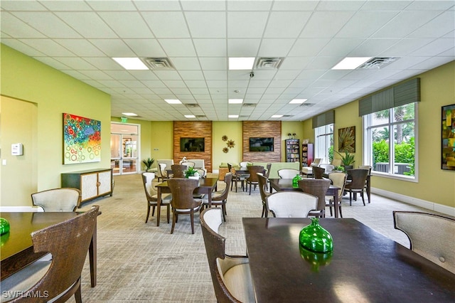 dining area featuring a drop ceiling and light colored carpet