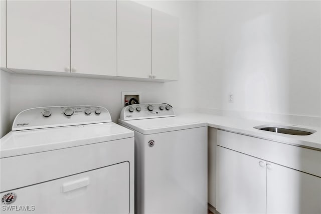 washroom with washer and dryer and cabinets