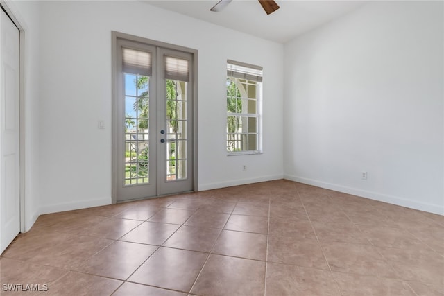 tiled spare room with ceiling fan and french doors