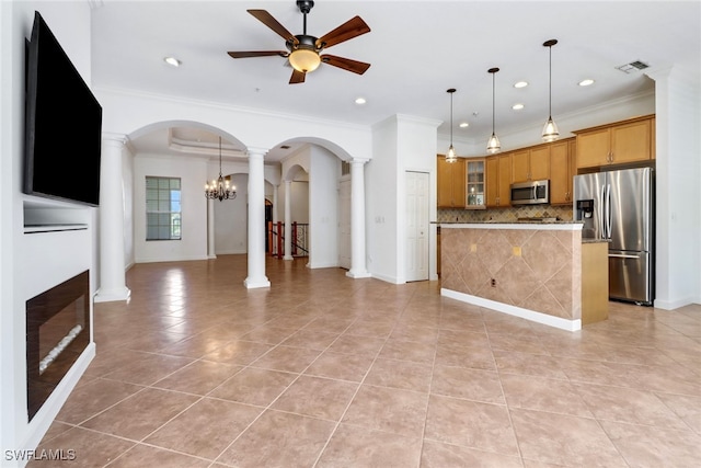 interior space featuring ceiling fan with notable chandelier, crown molding, light tile patterned floors, and ornate columns