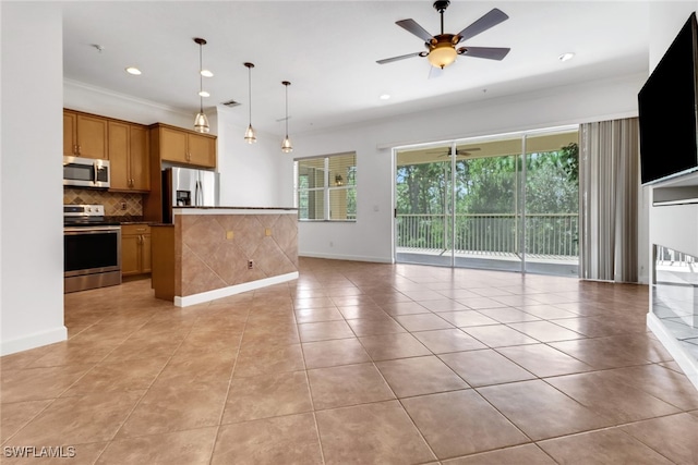 kitchen with appliances with stainless steel finishes, hanging light fixtures, decorative backsplash, ceiling fan, and ornamental molding