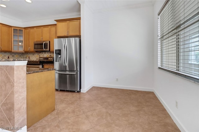 kitchen with stainless steel appliances, dark stone countertops, and crown molding