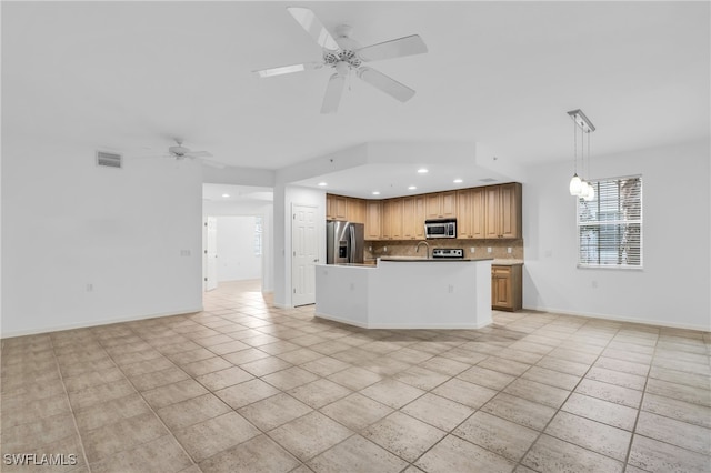 kitchen with appliances with stainless steel finishes, backsplash, pendant lighting, a center island, and ceiling fan