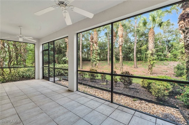 unfurnished sunroom with ceiling fan