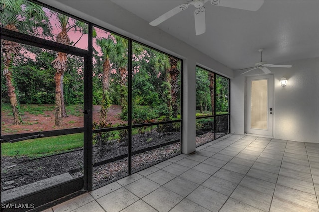 unfurnished sunroom with ceiling fan