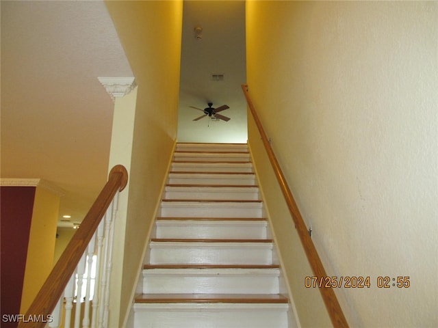 staircase featuring ceiling fan