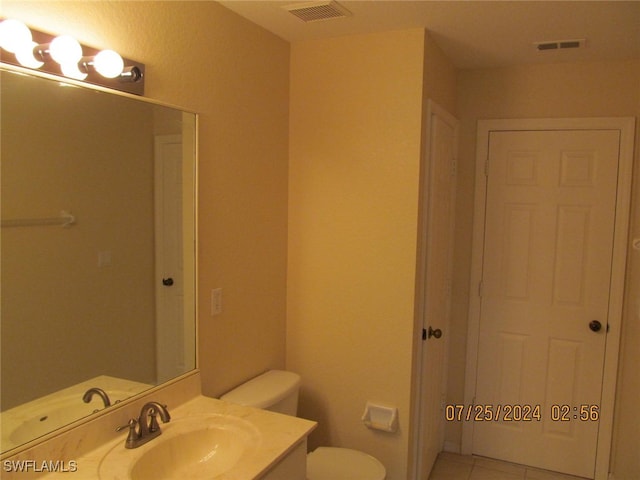 bathroom with vanity, toilet, and tile patterned floors