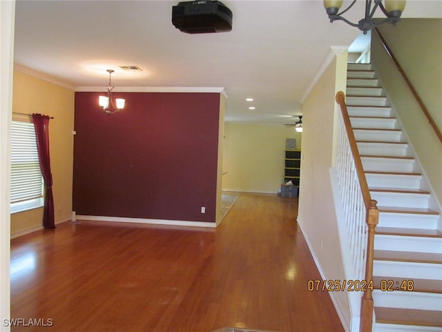 interior space featuring a notable chandelier, ornamental molding, and hardwood / wood-style floors