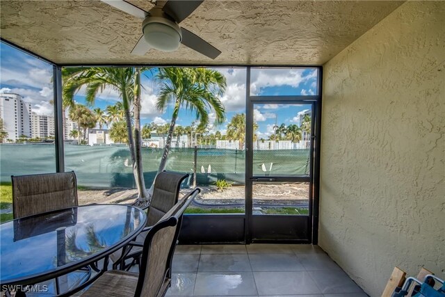 unfurnished sunroom with ceiling fan