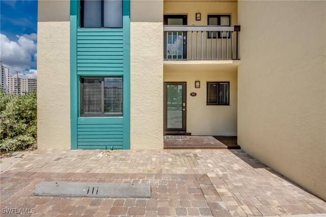 entrance to property with a balcony and a patio area