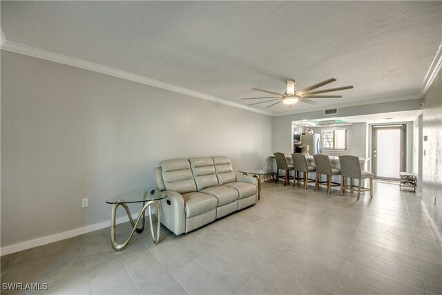 living room featuring crown molding, light tile patterned flooring, and ceiling fan