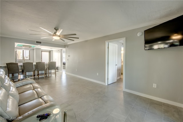 tiled living room featuring crown molding and ceiling fan