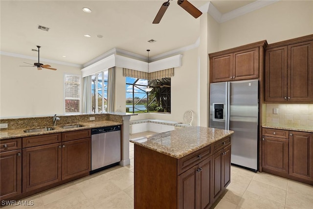 kitchen with sink, decorative light fixtures, stainless steel appliances, and light stone countertops