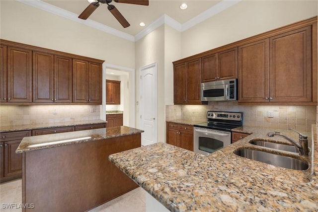 kitchen with sink, decorative backsplash, ornamental molding, light stone counters, and stainless steel appliances