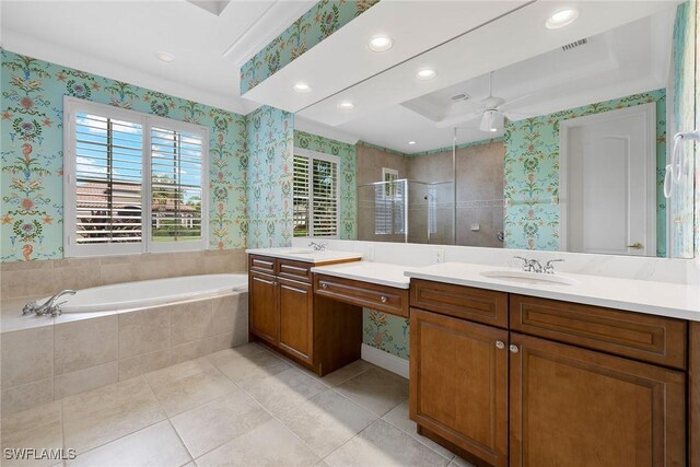 bathroom with vanity, tile patterned flooring, a tray ceiling, and separate shower and tub