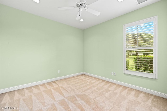 carpeted spare room featuring ceiling fan