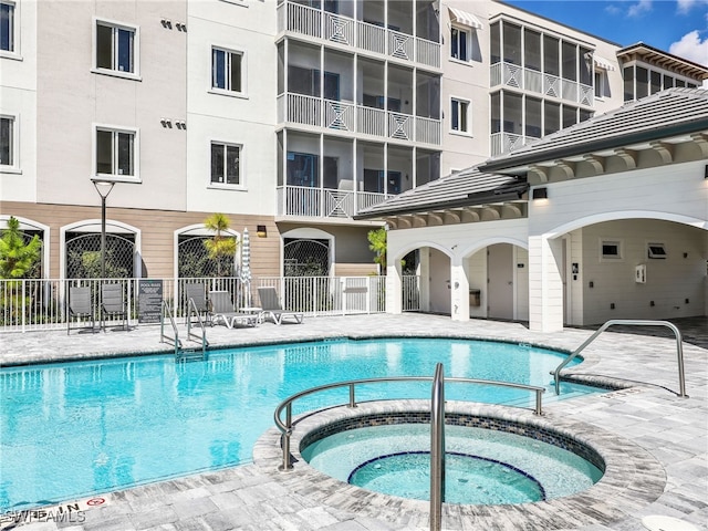 view of swimming pool featuring a community hot tub and a patio