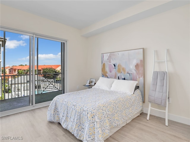 bedroom with access to outside, multiple windows, and light hardwood / wood-style flooring