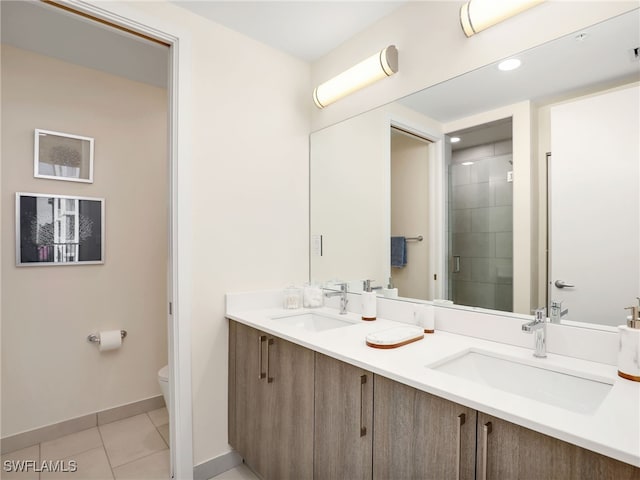 bathroom with tile patterned flooring, vanity, toilet, and a shower with shower door